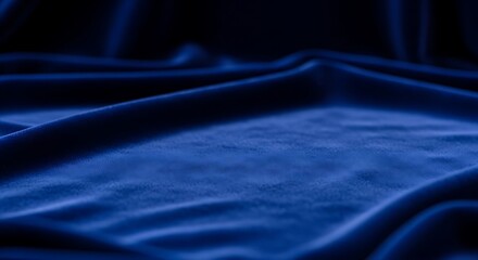 Close-up view of deep blue velvet fabric draped in folds.