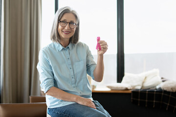 Senior woman showing pink ribbon supporting breast cancer awareness campaign