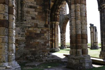Columns and arches frame a landscape, conveying a sense of history at Whitby Abbey - Whitby - North...
