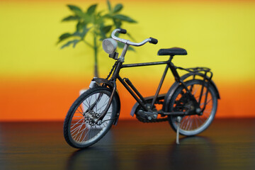 Vintage bicycle miniature against a gradient background with a decorative plant providing a warm...