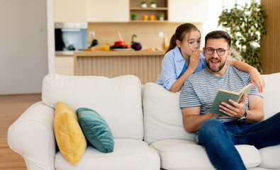 Joyful reading time between a father and daughter in a cozy home setting