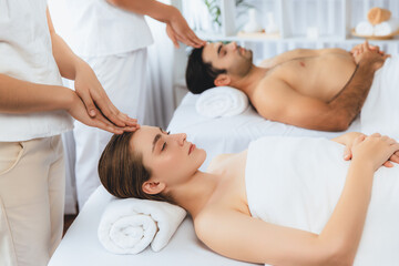 Caucasian couple enjoying relaxing anti-stress head massage and pampering facial beauty skin...
