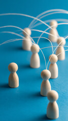Obraz premium Wooden figures connected by white lines on blue background people connection