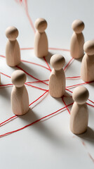 Obraz premium Wooden figures connected by red thread peg people connection