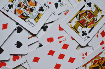 Playing cards, the deck is scattered chaotically on the floor.	