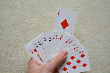 Playing cards, the deck is scattered chaotically on the floor.	