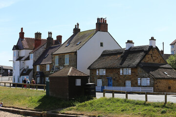 Row of quaint coastal buildings, each with unique architectural features, line a road  in Sandsend...