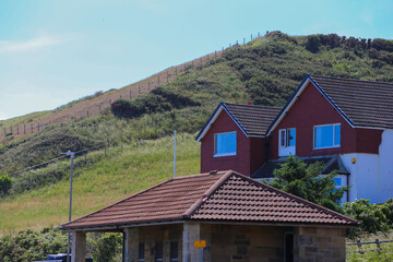 A suburban scene showing a house below a grassy hill  in Sandsend - North Yorkshire - United Kingdom