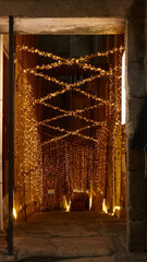 Entrance to cozy basement bar decorated with warm fairy lights and bamboo walls at night. Concept of coziness and secret evenings in a hidden bar