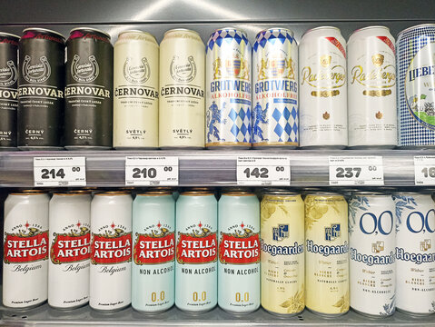 Variety of canned beers on retail store shelf with prices displayed