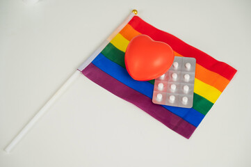 Rainbow flag, pills, heart and stethoscope.