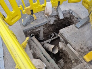 View inside an open utility access point, revealing infrastructure and piping.