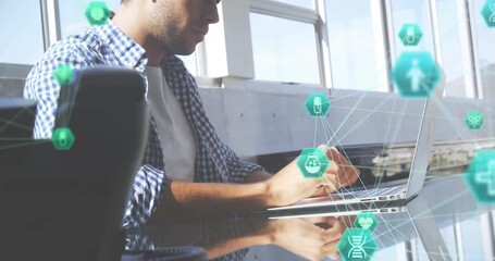 Male data analyst opening laptop typing while green medical icons illustrating data processing - Powered by Adobe