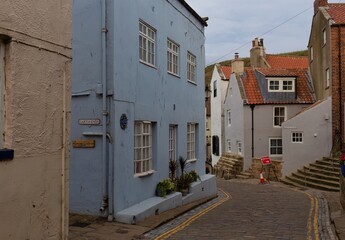 A quaint coastal village, showcasing a blue building with white-framed windows  in Staithes - North Yorkshire - United Kingdom