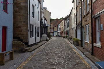 Narrow cobblestone street between buildings with windows, shot to fill the frame  in Staithes - North Yorkshire - United Kingdom