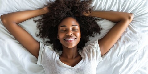 A woman laughing and looking up at the ceiling, enjoying a moment of relaxation on her bed.