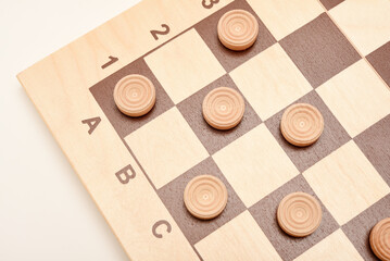 Wooden checkers on the board. The board game checkers.