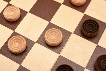 Wooden checkers on the board. The board game checkers.