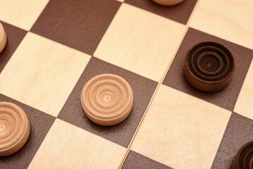 Wooden checkers on the board. The board game checkers.