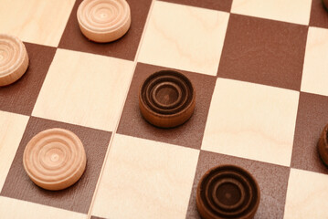 Wooden checkers on the board. The board game checkers.