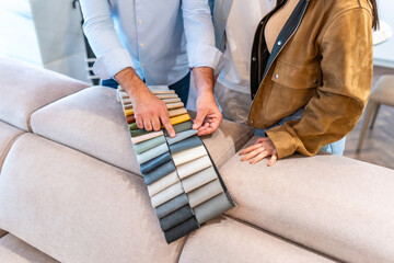 Salesman showing fabric swatches to customer in furniture store