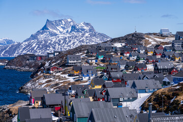 Scenic view of colorful houses nestled along the coast of Nuuk, Greenland, with Sermitsiaq mountain...