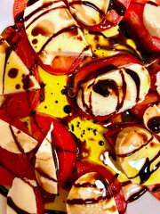 Mozzarella with tomatoes, olive and balsamic vinegar.