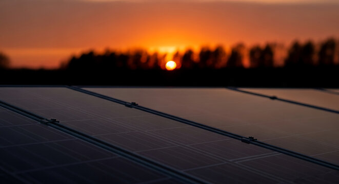 Close-up of dark solar panels at sunset, showcasing clean energy and environmental sustainability, symbolizing renewable resources and a brighter future - Powered by Adobe
