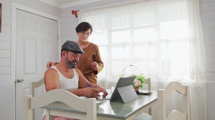 Senior hispanic couple organizing home finances together at kitchen table - Powered by Adobe