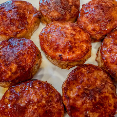 Closeup of fried sausage patties on a white plate with square crop