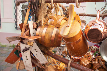traditional wooden and metal kitchen utensils hanging for sale at a street market.
