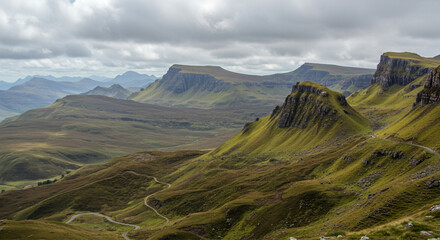 Mountain Range with Winding Valley Road and Cloudy Peaks
