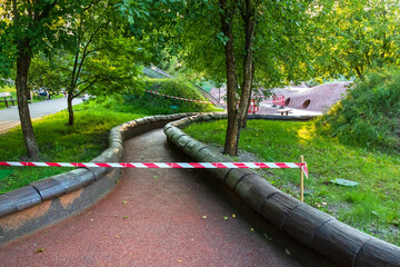Part of a public park is blocked off with warning tape. An alley is closed with Barricade tape at a children's playground in Kharkiv city, Ukraine