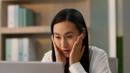 Close up surprised amazed Asian Japanese office worker manager business woman Chinese Korean female...