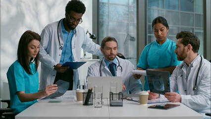 Multicultural ethnic five diverse people doctors nurses Caucasian Indian African clinician medical healthcare therapists talk meeting conference disease checkup surgery discussion x-ray tablet clinic