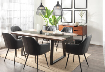 Elegant dining room in mid-century modern style with black leather chairs, wood table with iron...