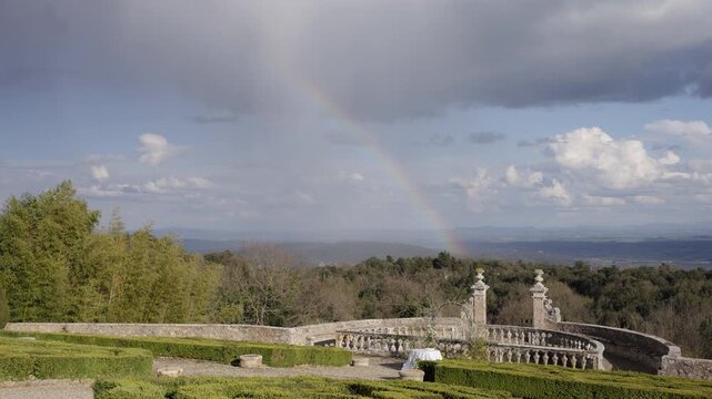 Rainbow appearing over a scenic balcony in bomarzo, italy. Action