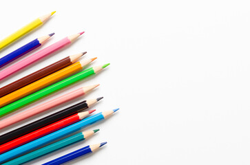 Collection of colorful sharpened pencils on a white background with copy space.