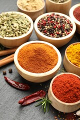 Different aromatic spices on black table, closeup