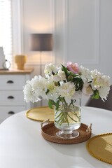 Beautiful table setting with vase of flowers in dining room