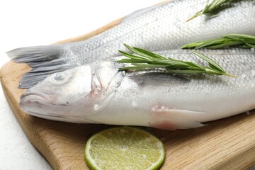 Fresh raw seabass with spices on white table, closeup. Fish and seafood delicacies