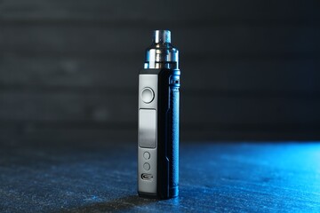 Modern electronic smoking device on black table