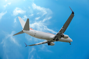 Obraz premium Airplane flying in beautiful blue sky with clouds