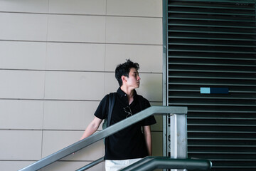 young man standing on a staircase near minimalist architecture