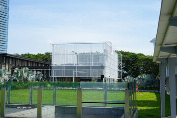 modern glass architecture surrounded by lush green landscape in urban setting