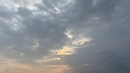 Moody gray cloudscape reveals the sun peeking through, creating soft light rays across the sky