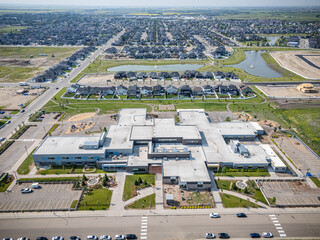 Large school building with a parking lot in front of it