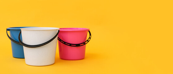 Plastic buckets on color background