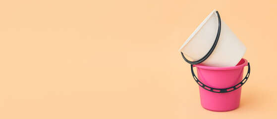 Plastic buckets on color background