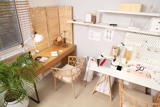 Sketches of stylish accessories with tools on jeweler table in workshop - Powered by Adobe